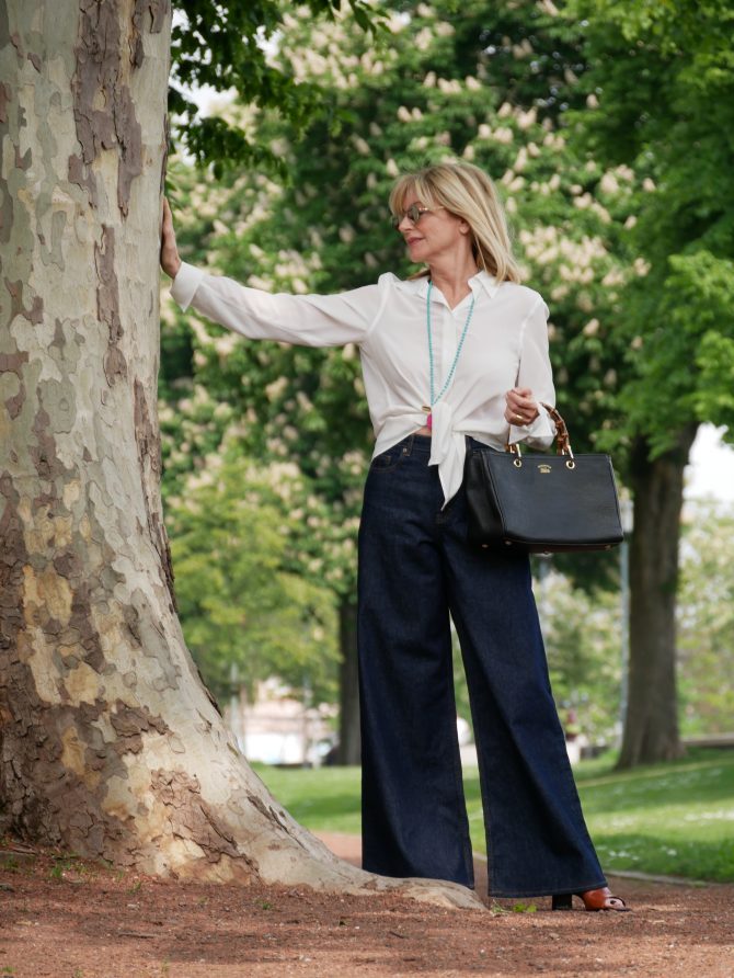 charismalook-volumen-jeans-beitragsfoto-mode-baum-frau-seidenbluse-tasche
