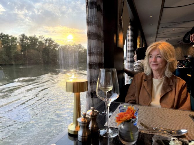 Dinner an Bord der Ravel – gedeckter Tisch mit Blick auf die Rhône in der Provence, Tina Artz halb im Bild.