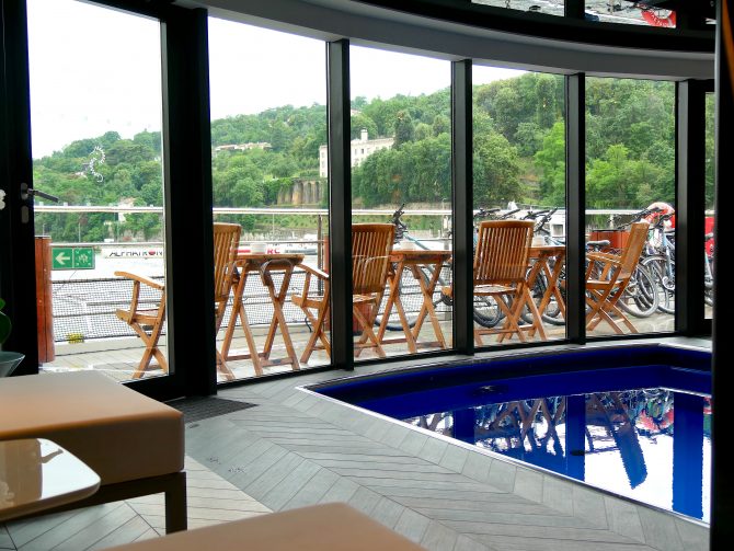 Blick vom Spa-Bereich aufs Achterdeck der Ravel – stilvolle Holzstühle und ein kleiner Pool mit Provence-Flair