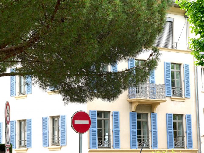 Typisches Provence-Haus mit blauen Schlagläden und einem dekorativen Baum – mediterrane Stimmung entlang der Reiseroute.