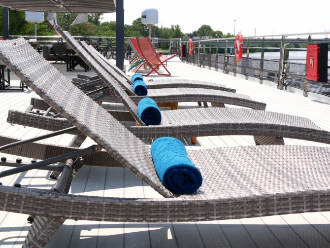 Sonnenliegen mit Handtüchern auf dem Deck der Ravel – Ruhe, Sonne und Weitblick über die Rhône in der Provence.