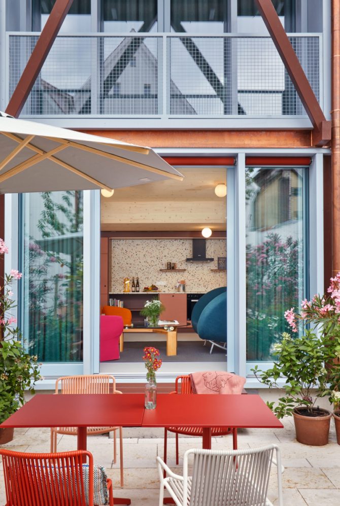 Offene Fenster, mit Blick nach innen in ein Wohnzimmer, Im Vordergrund ein Gartentisch