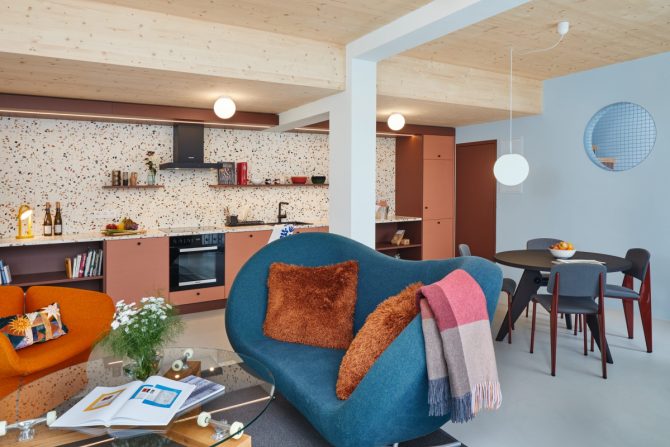 Apartment mit Sofa, Esstisch und Küchenzeile in kräftigen Farben