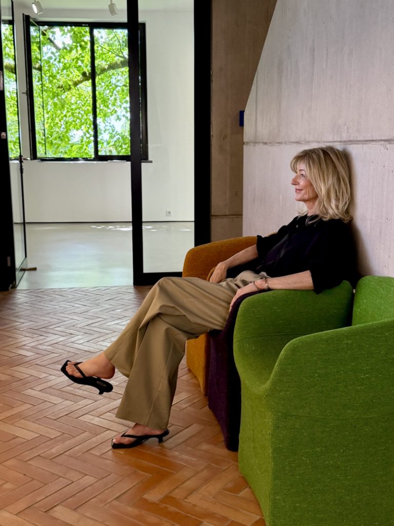 Tina Artz sitzt im Flur der Galerie Zink in einem Seesel